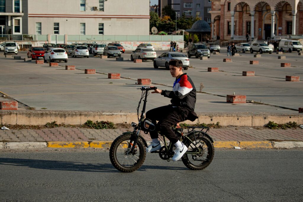 Teenage boy riding an e-bike on a city street